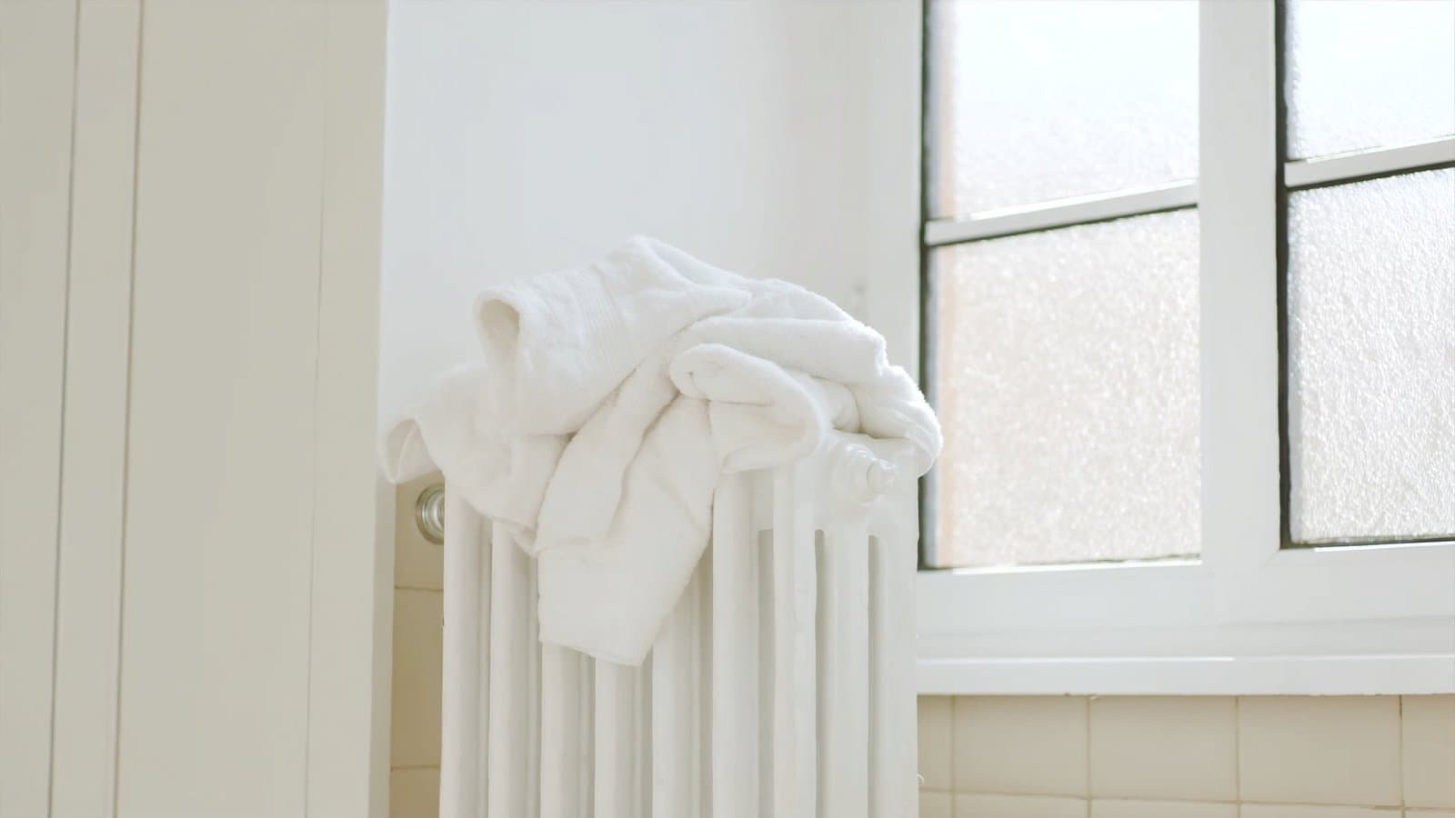 Handdoeken over een warme radiator in een lichte badkamer