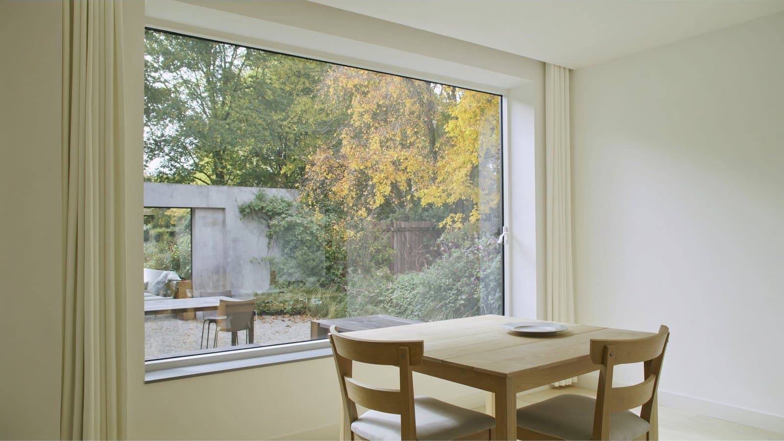 Een lichte eethoek met zicht op de tuin